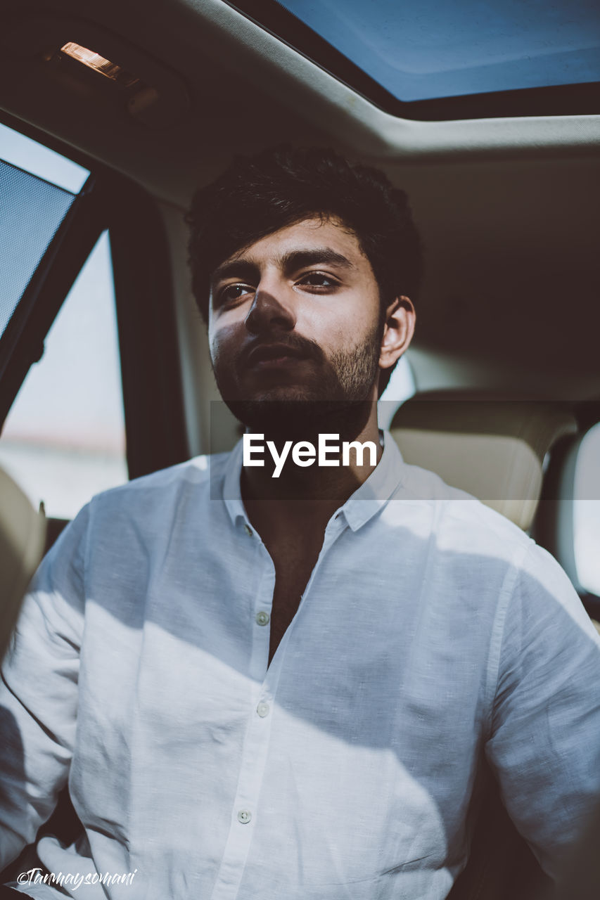 Thoughtful young man sitting in car