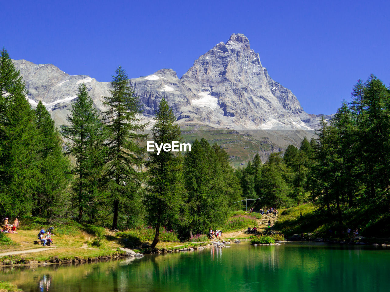 scenic view of lake and mountains against clear blue sky