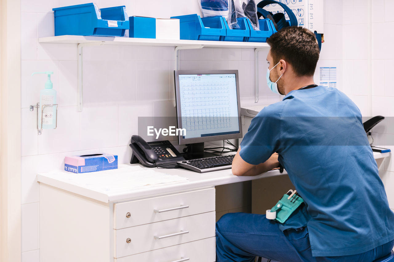 Doctor working on computer at desk in hospital