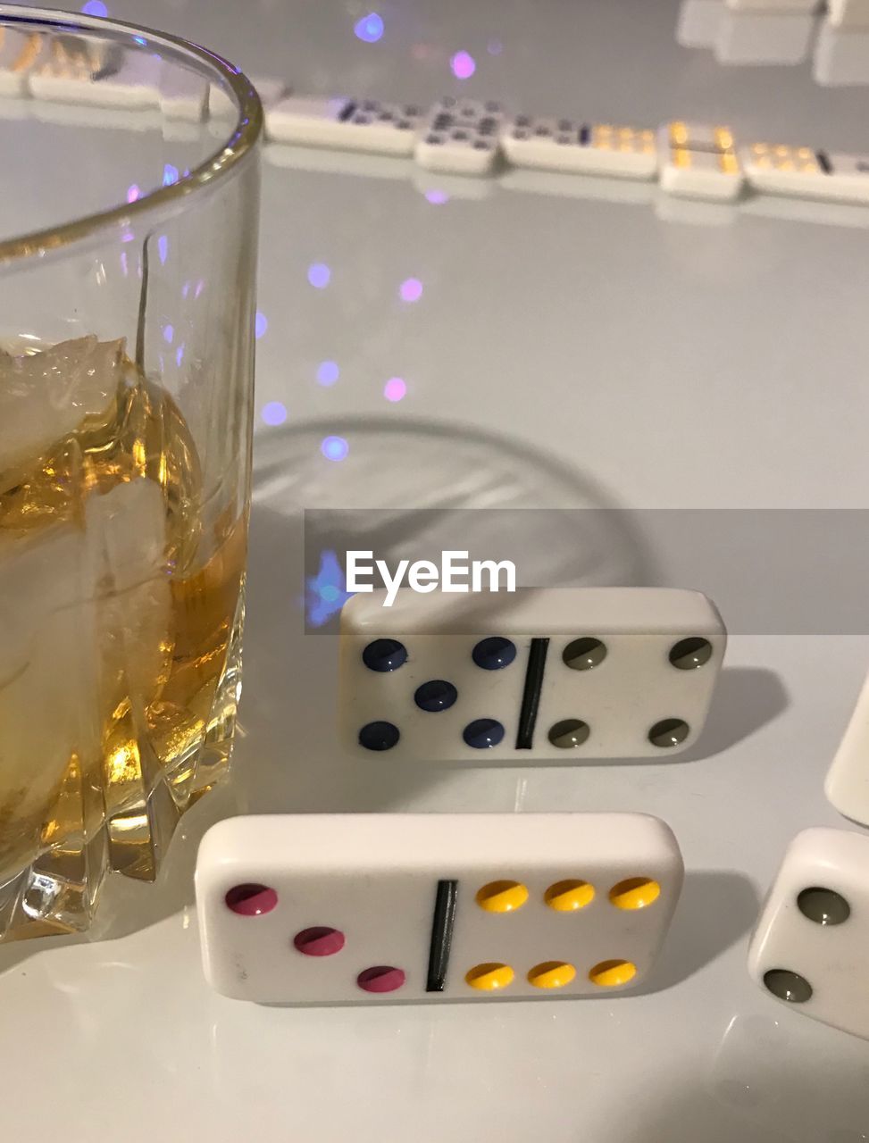 Close-up of dominoes by drink on table