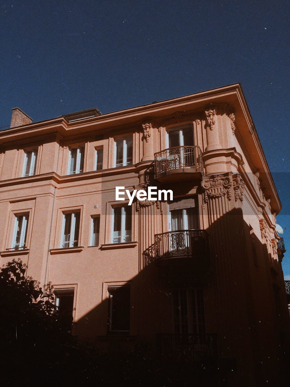 LOW ANGLE VIEW OF RESIDENTIAL BUILDING AGAINST CLEAR SKY