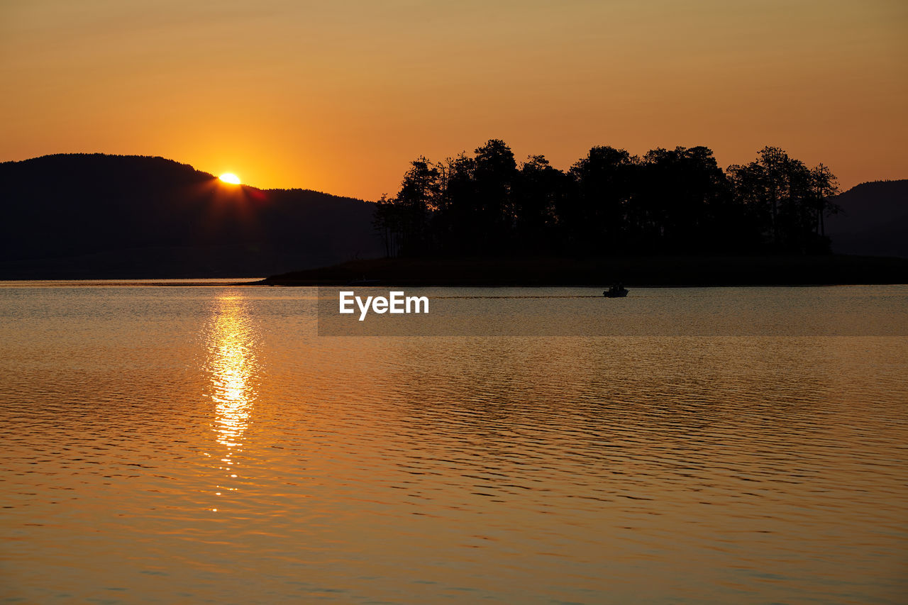 SILHOUETTE TREES BY LAKE AGAINST SKY DURING SUNSET