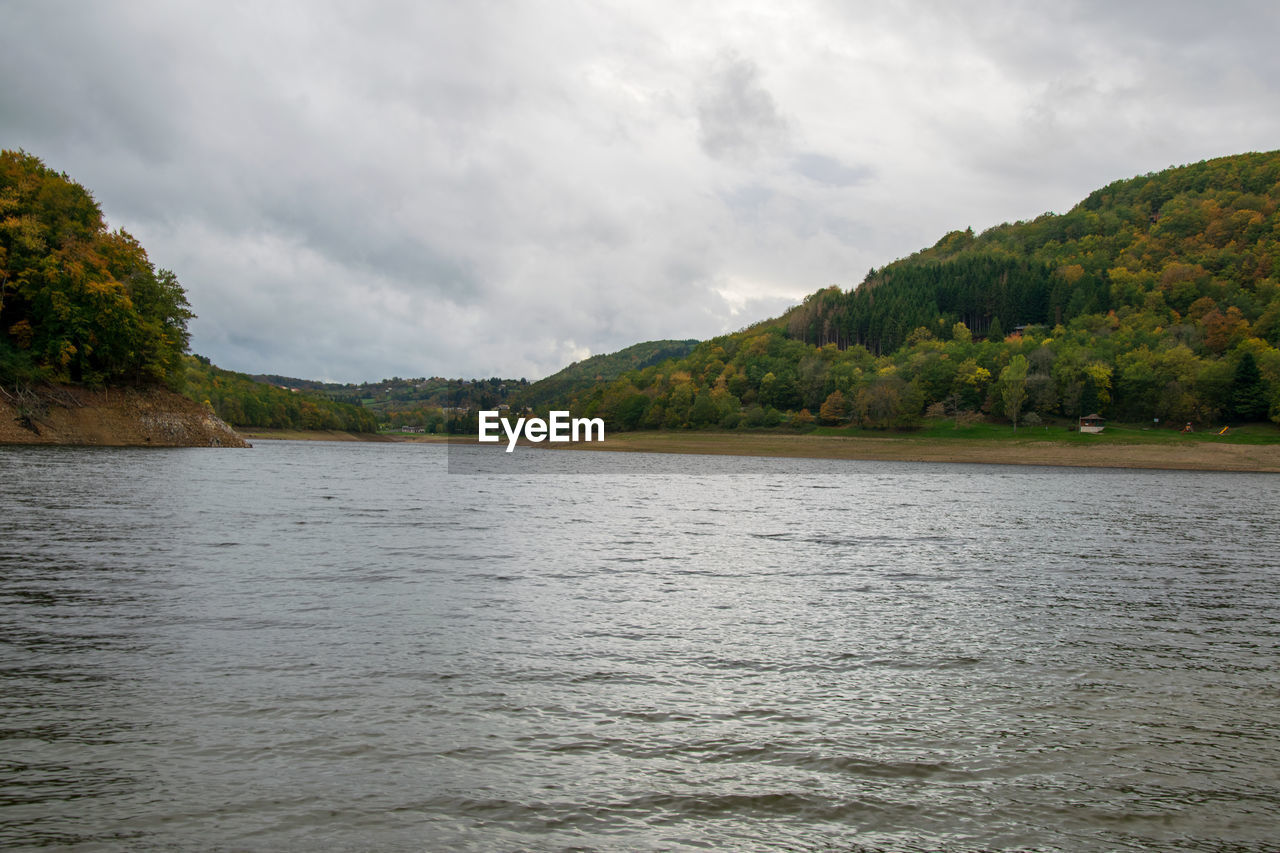 SCENIC VIEW OF LAKE BY TREES AGAINST SKY