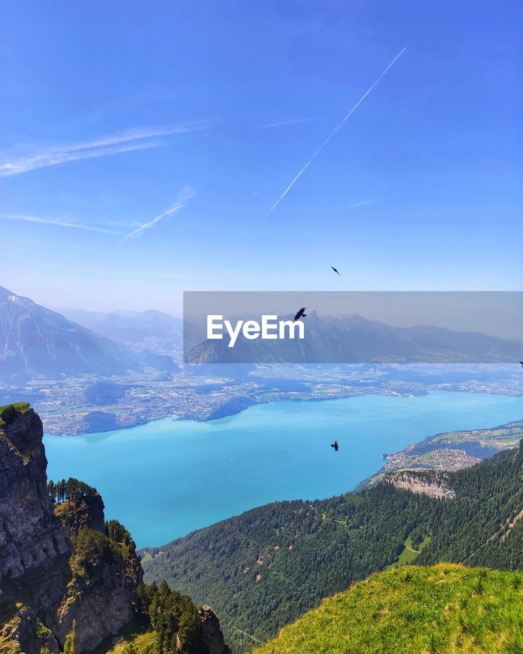 Scenic view of sea and mountains against blue sky