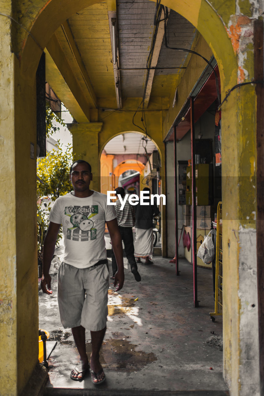 REAR VIEW OF PEOPLE WALKING IN BUILDING