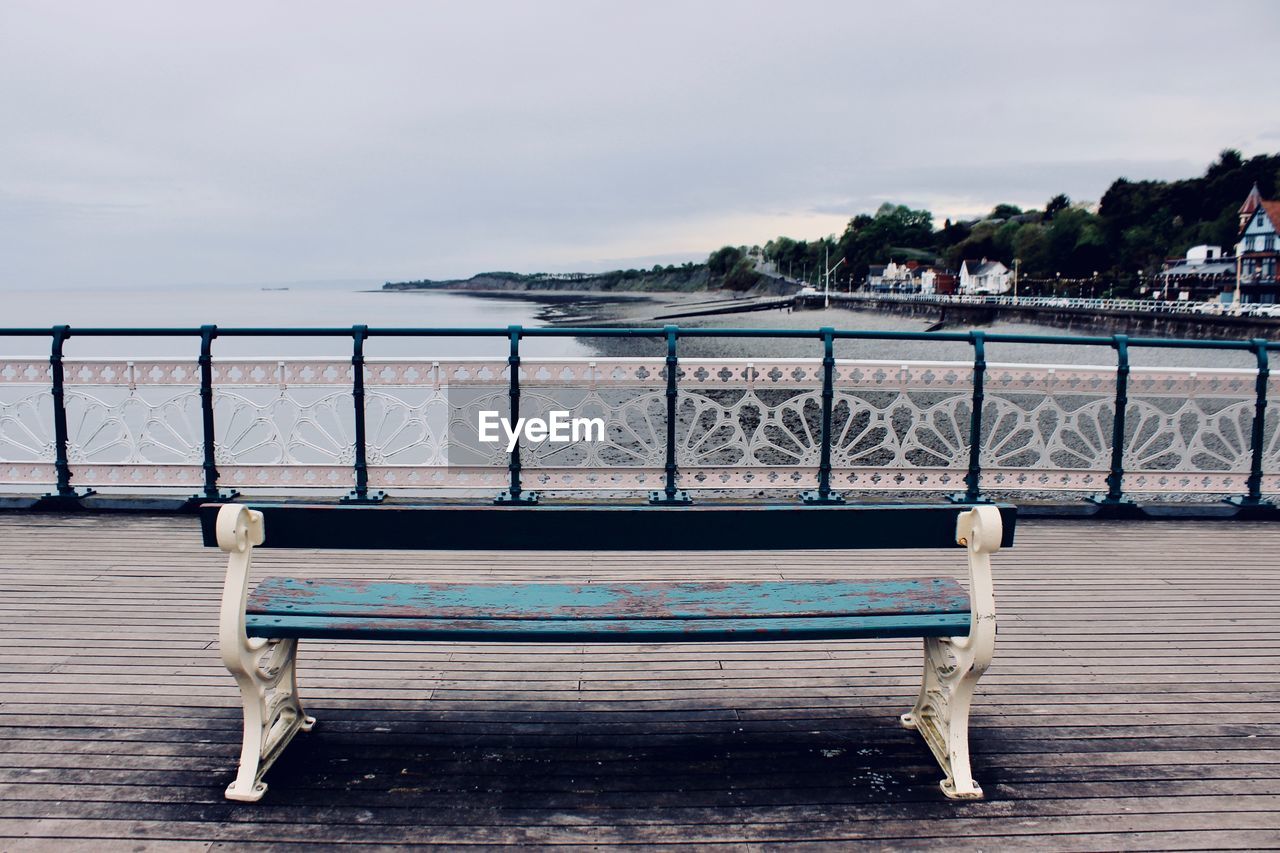 BENCH IN SEA AGAINST SKY