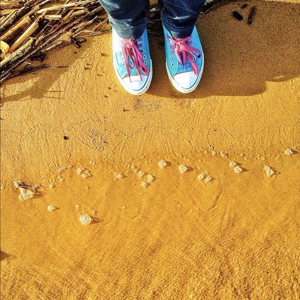 LOW SECTION OF WOMAN STANDING ON BEACH