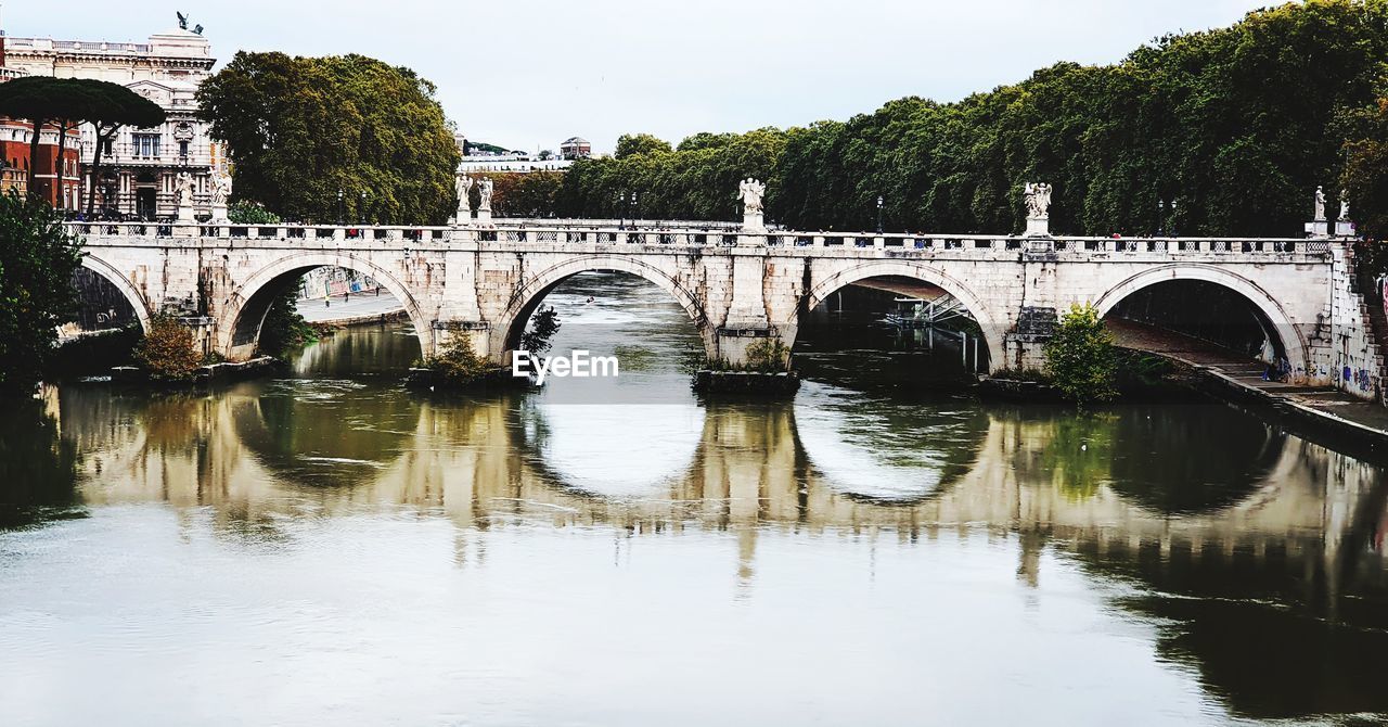 Arch bridge over river against sky