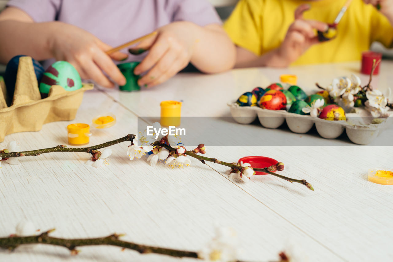 Children's hands that close the can of paint. preparing for a happy easter holiday