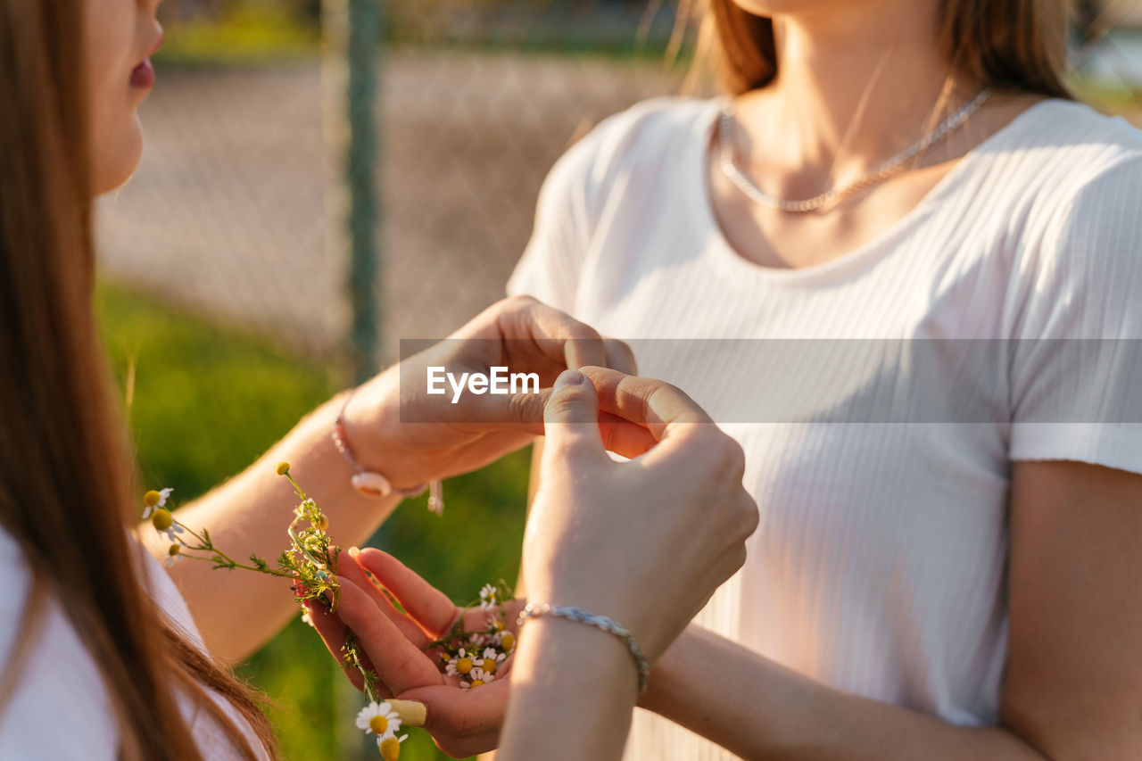 Teenage girls putting flowers in hair