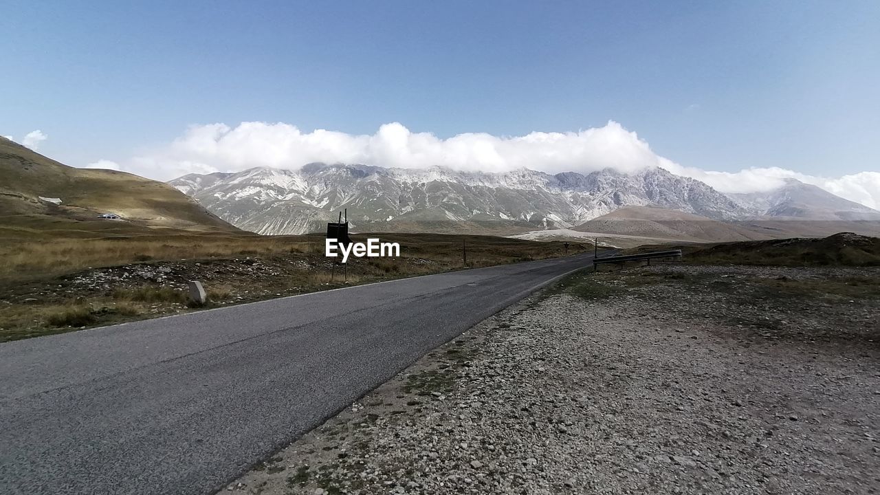 EMPTY ROAD BY MOUNTAIN AGAINST SKY