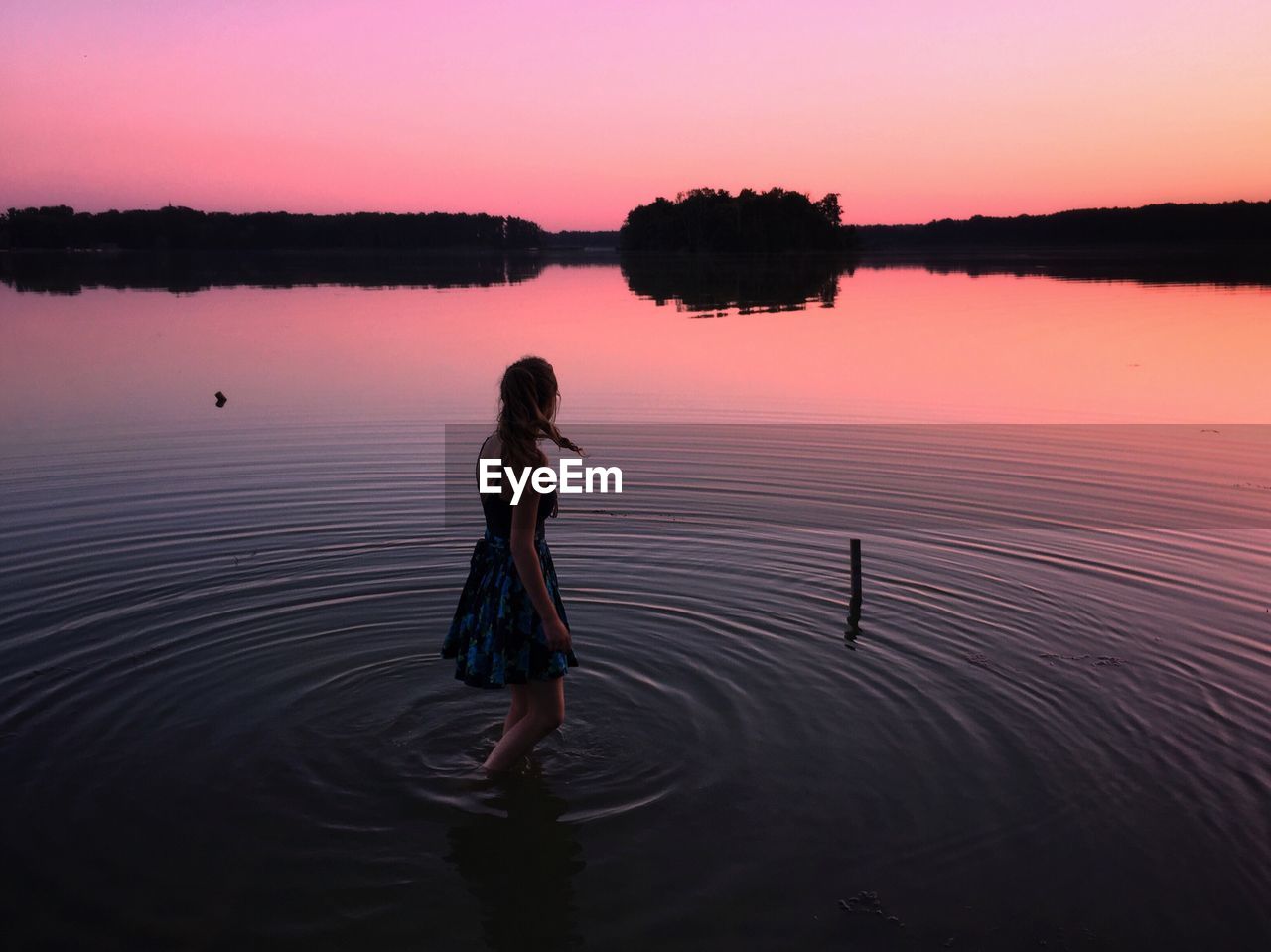 Woman in lake during sunset