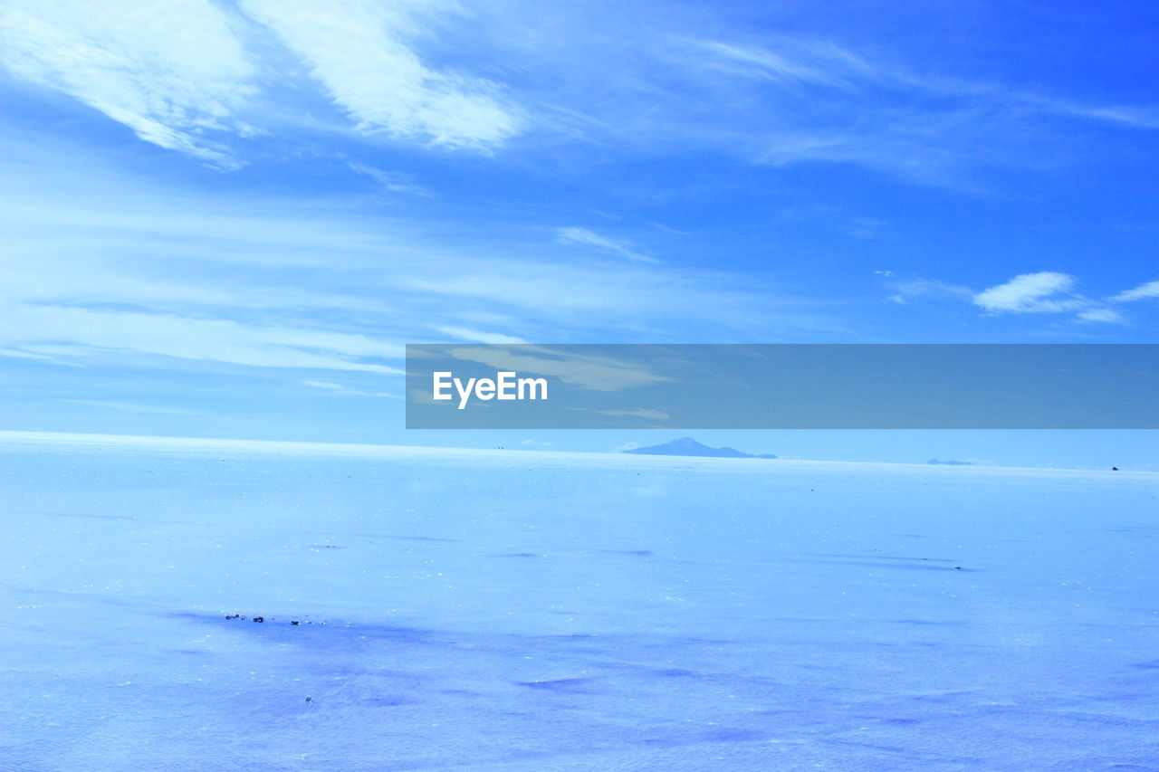 SCENIC VIEW OF SEA AGAINST BLUE SKY DURING WINTER