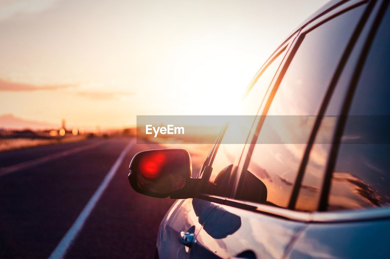 CLOSE-UP OF SUNGLASSES ON ROAD AGAINST SKY