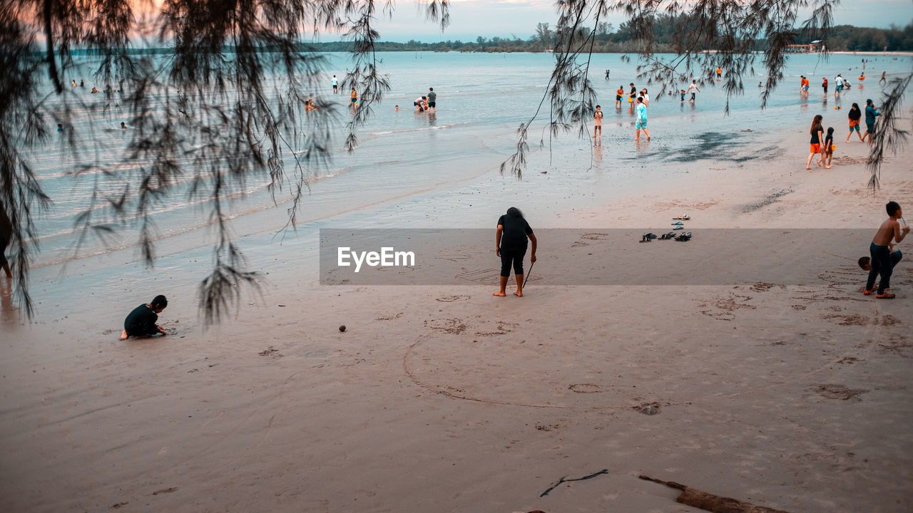 water, beach, land, group of people, nature, body of water, sand, large group of people, winter, crowd, sea, tree, men, sky, leisure activity, lifestyles, women, reflection, day, beauty in nature, holiday, vacation, outdoors, adult, scenics - nature, trip, shore