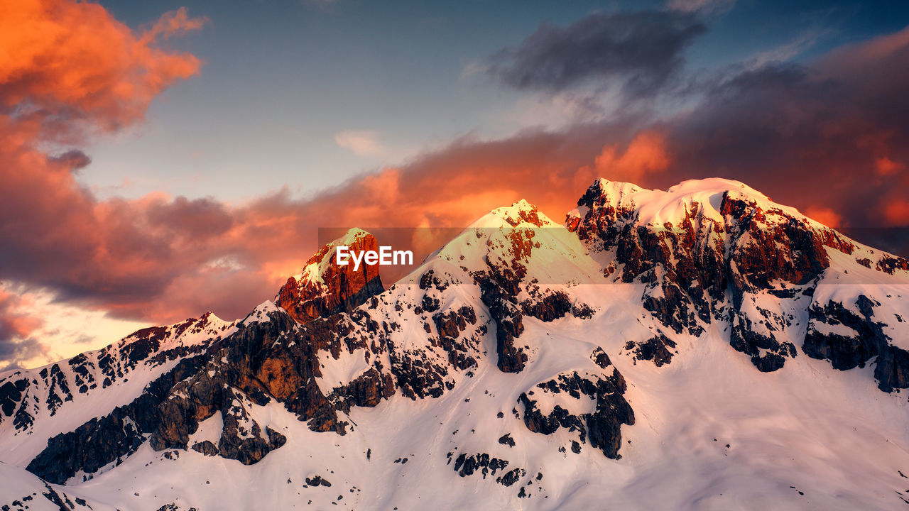 Snow covered mountains against sky during sunset