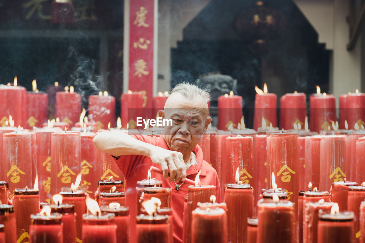 Man igniting candle in temple