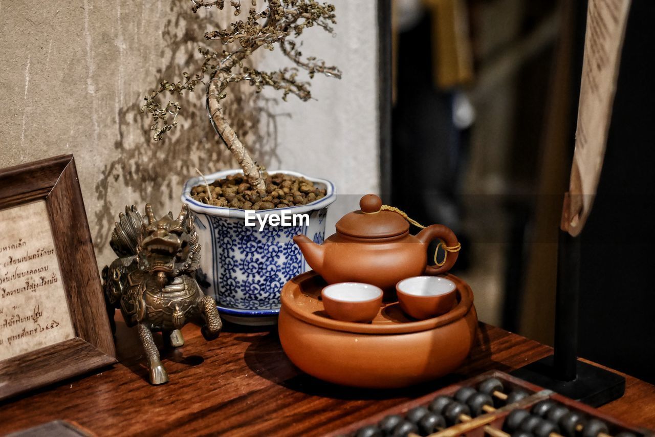 TABLE AND POTTED PLANT ON WOODEN FLOOR