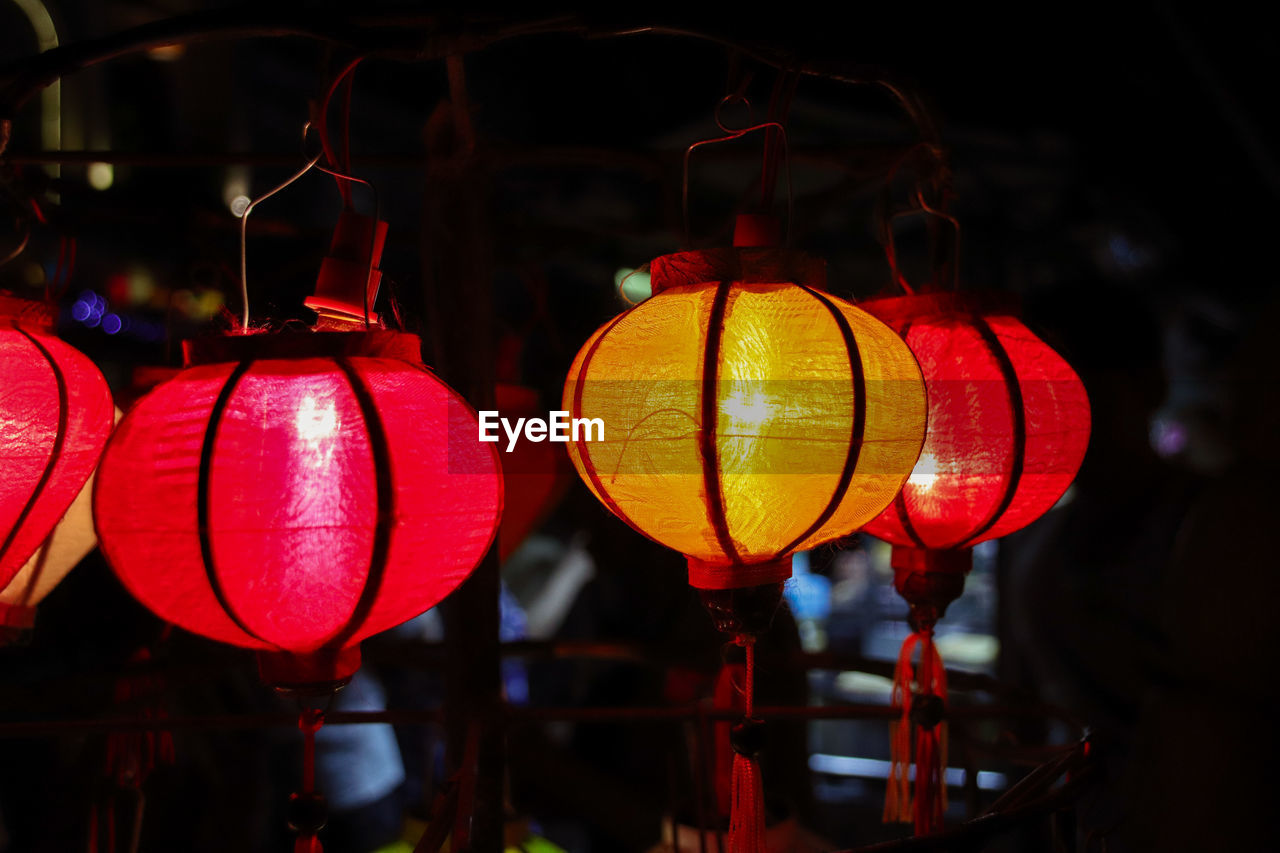 Close-up of illuminated lanterns hanging at night