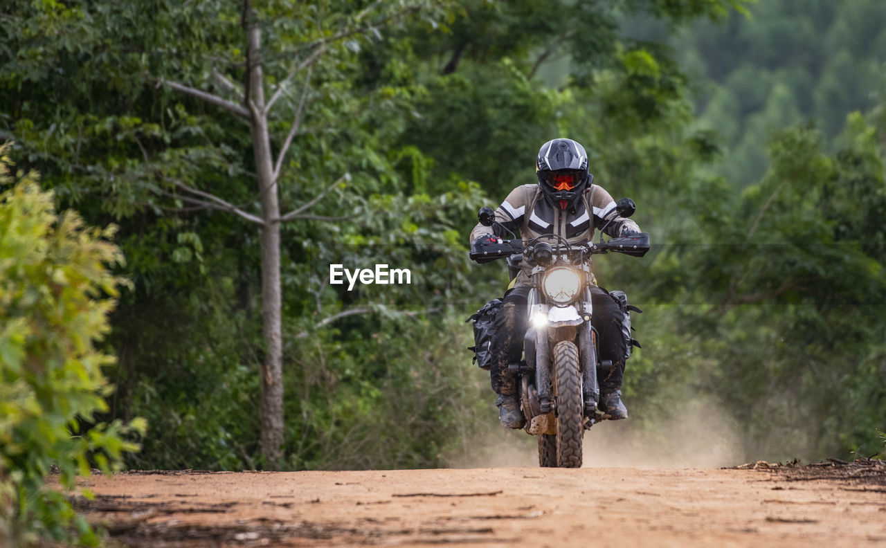 Man riding his motorbike on gravel road in pak chong / thailand