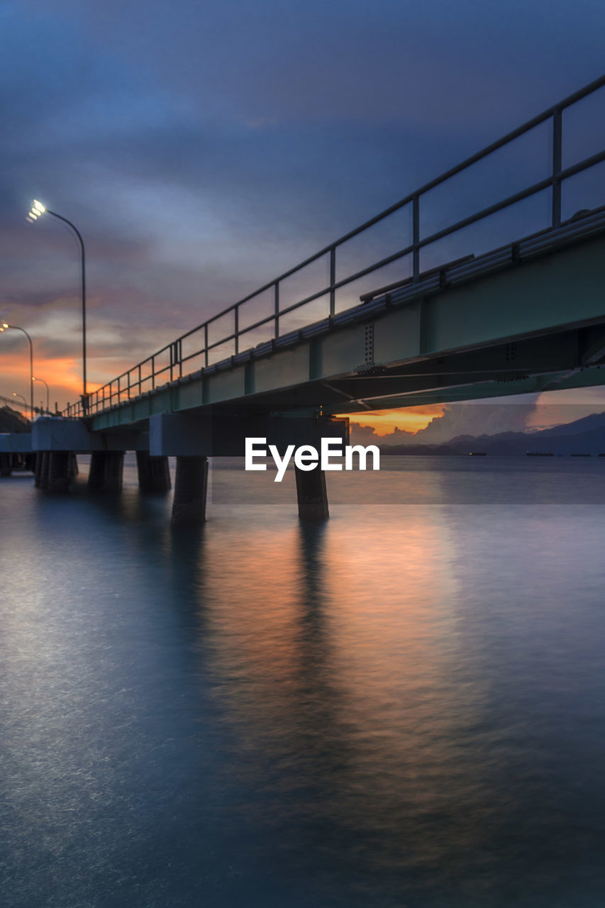 bridge, reflection, architecture, built structure, transportation, water, sky, beam bridge, dusk, evening, nature, illuminated, river, city, sunset, engineering, night, cloud, travel destinations, long exposure, waterfront, street light, outdoors, mode of transportation, motion, travel, twilight, street, building exterior, horizon, light