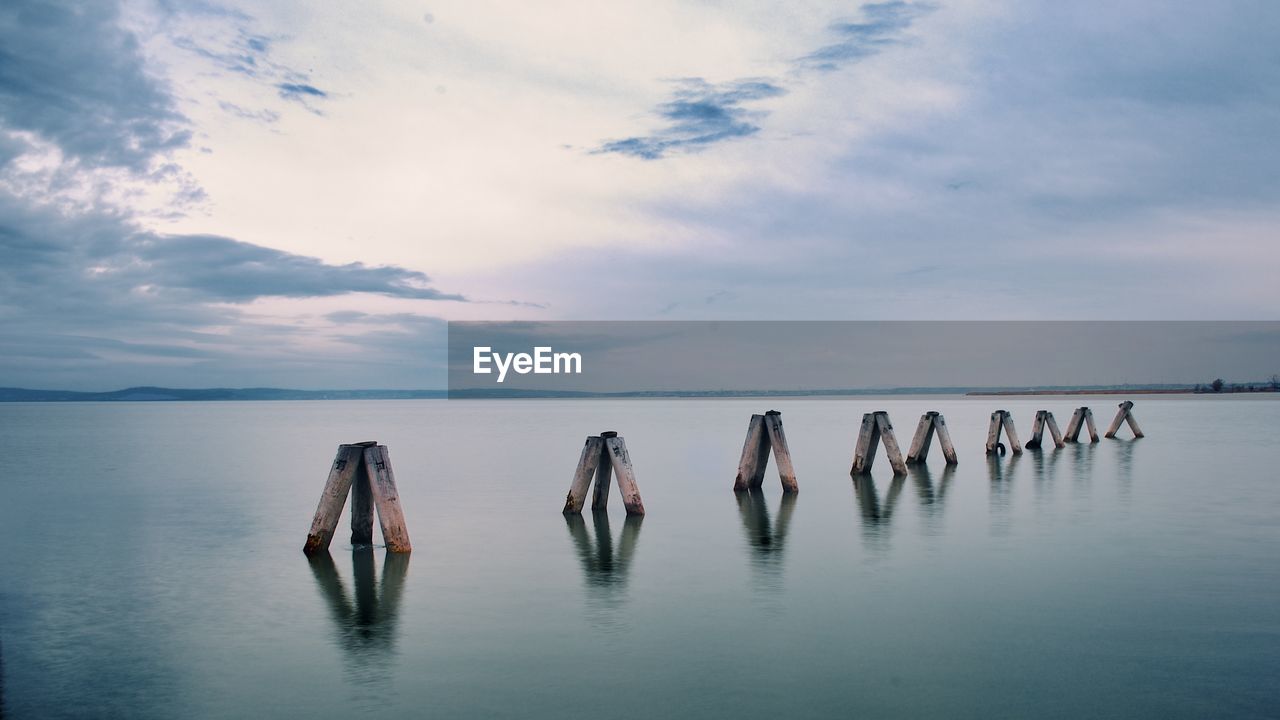 PANORAMIC VIEW OF WOODEN POSTS IN SEA