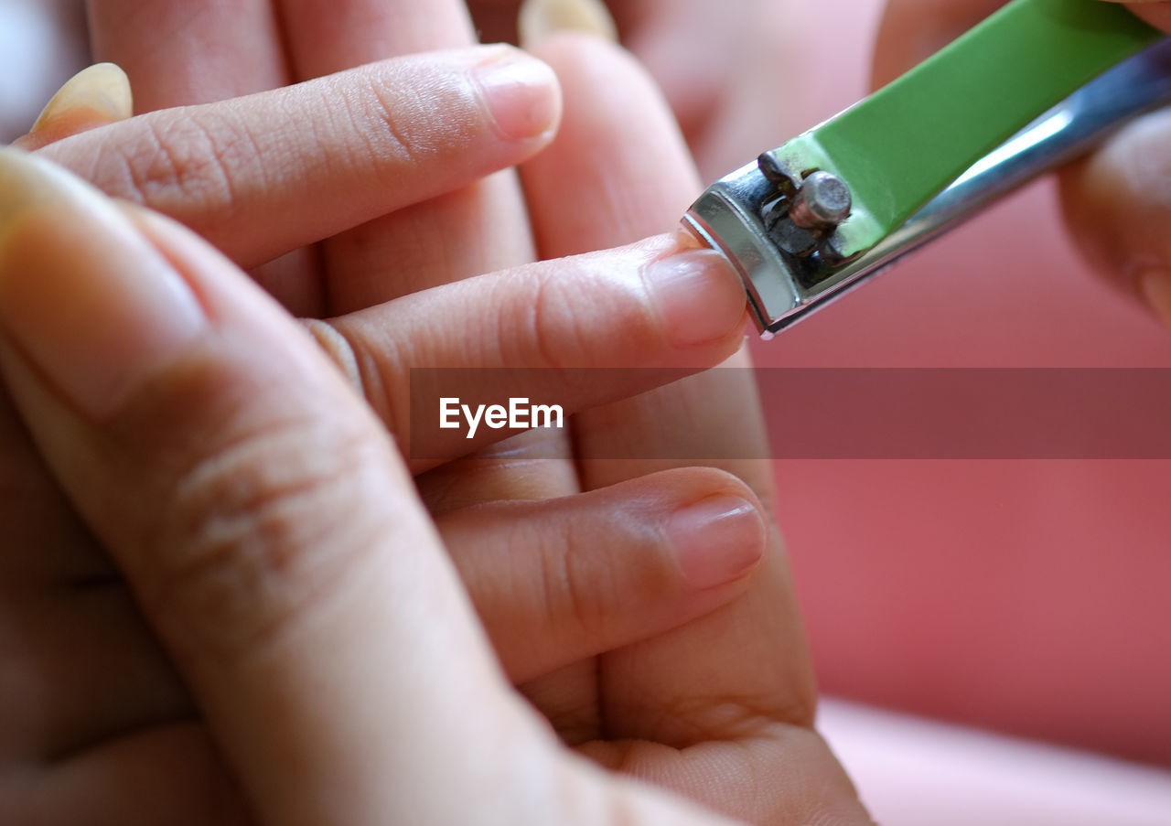 Close-up of woman clipping nails