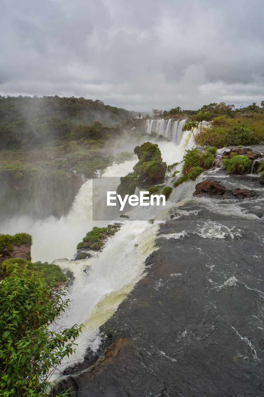 SCENIC VIEW OF WATERFALL AGAINST SKY DURING SUNRISE