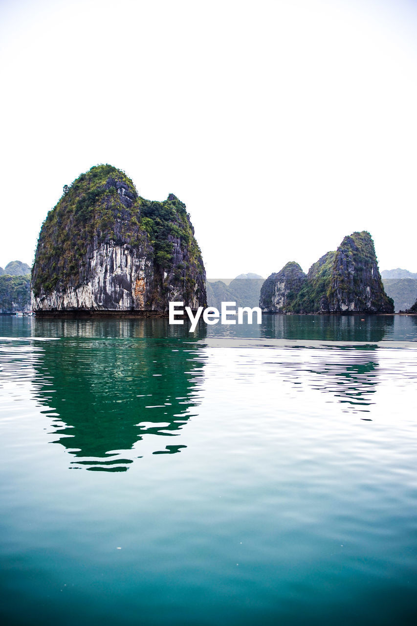 Rock formations in sea against clear sky