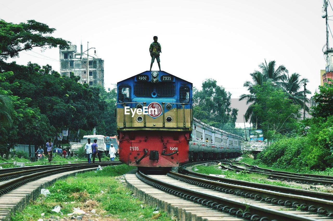 Boy standing on train against sky