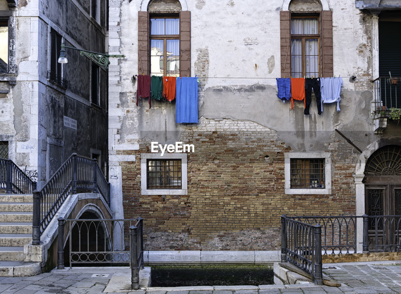 LOW ANGLE VIEW OF CLOTHES HANGING ON BUILDING