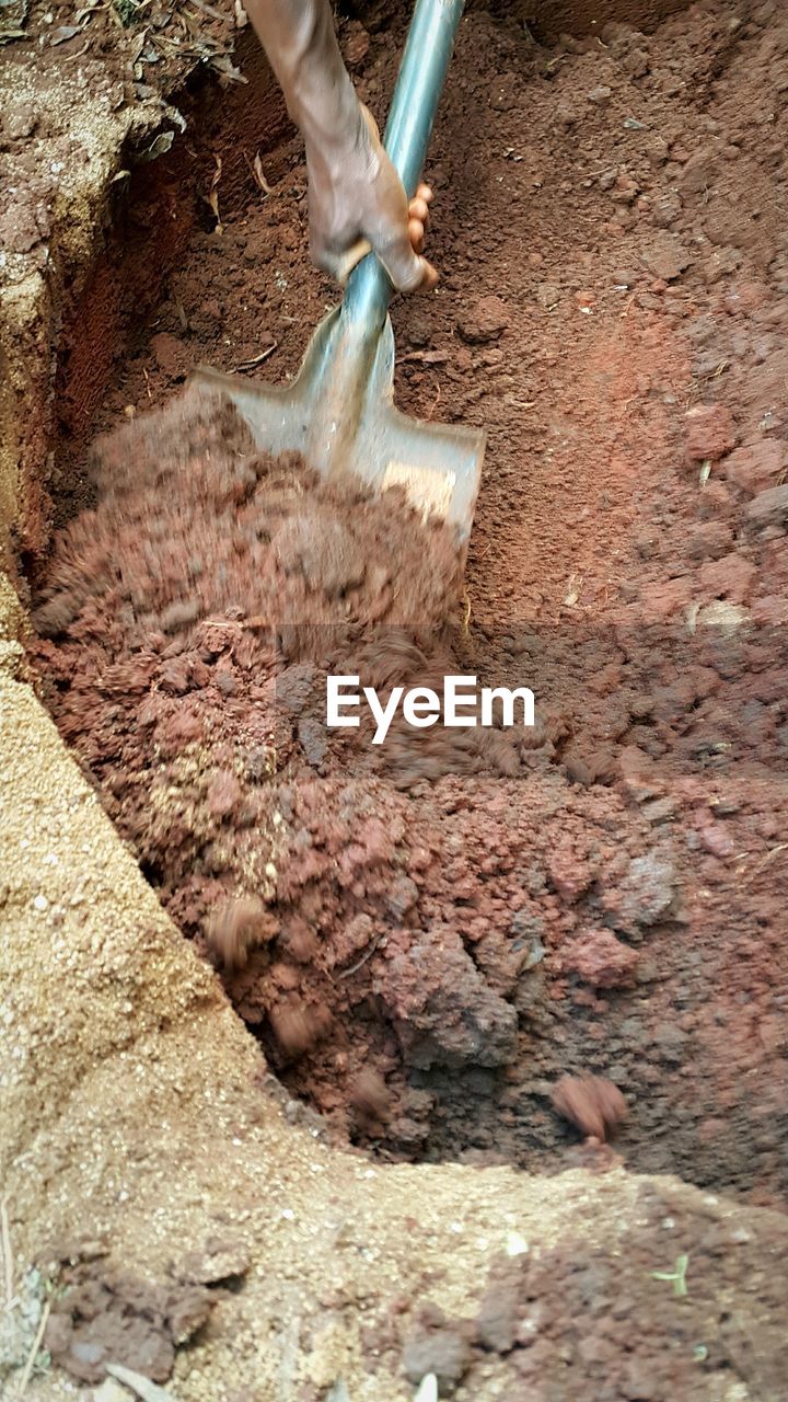 High angle view of worker digging dirt