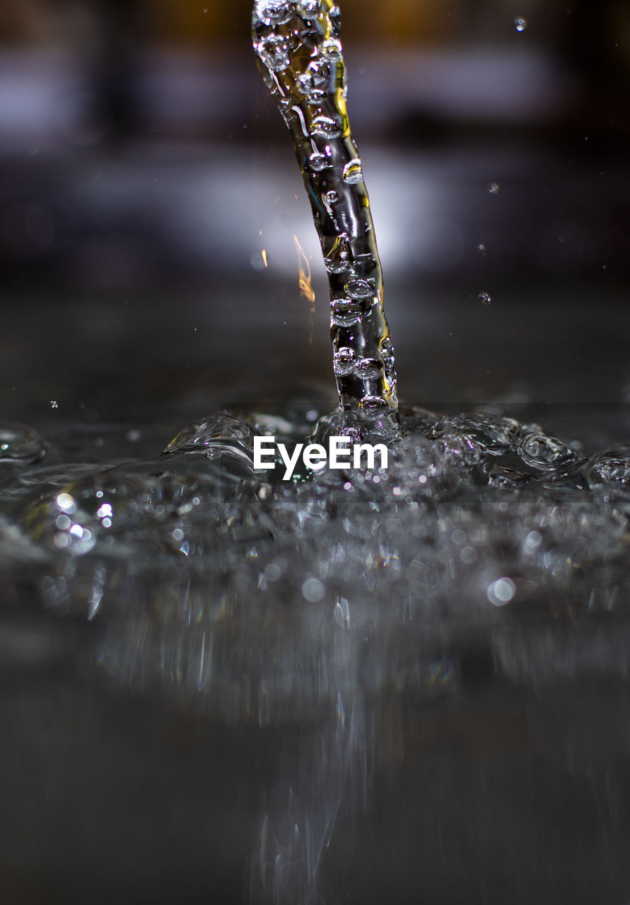 Close-up of drop falling on water