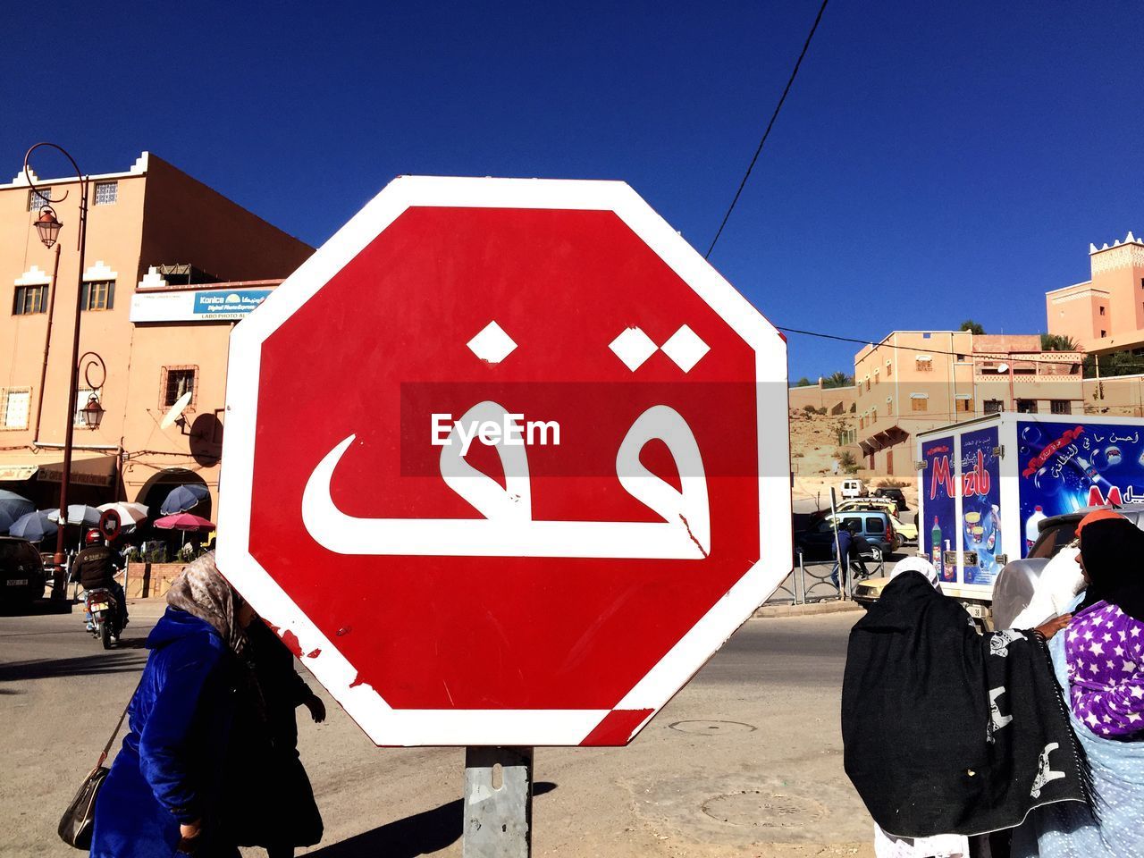 People walking against road sign on street