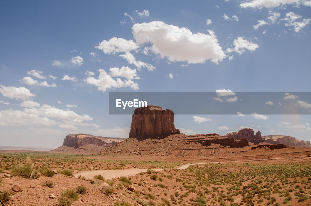 View of rock formations in desert against cloudy sky