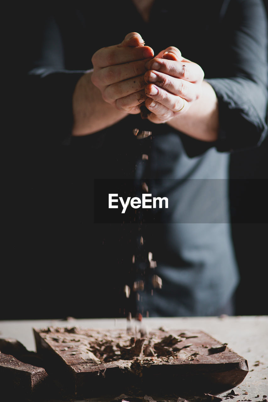 Close-up of baker's hands breaking chocolate