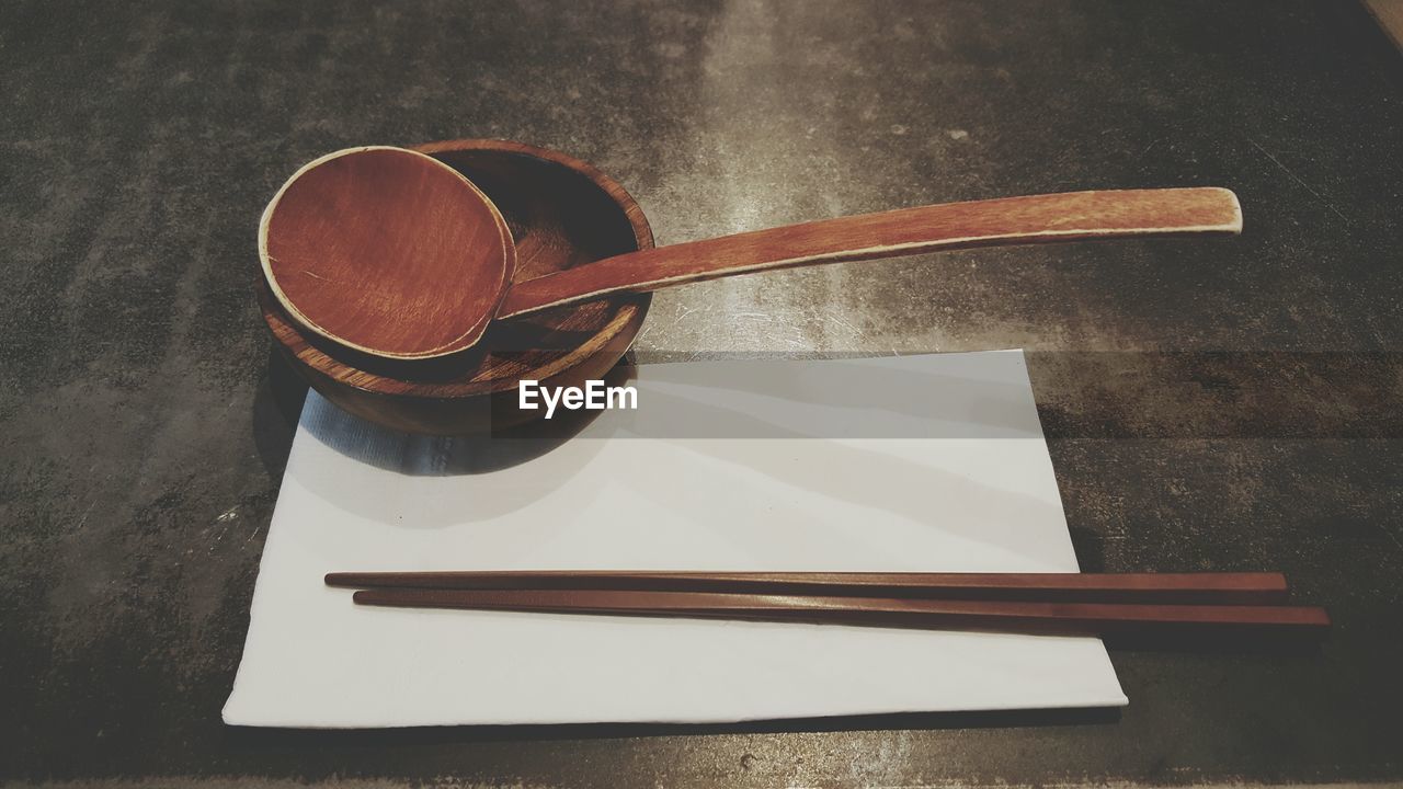 High angle view of chopsticks and wooden spoon on table