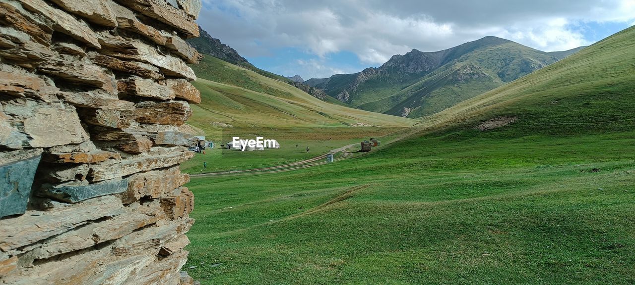 environment, landscape, mountain, scenics - nature, mountain range, land, nature, beauty in nature, sky, highland, grass, cloud, valley, green, plant, mountain pass, travel, travel destinations, no people, non-urban scene, tranquility, tranquil scene, activity, ridge, rural scene, field, outdoors, plateau, rock, tourism, day, meadow, terrain, idyllic, social issues, environmental conservation, water, architecture, leisure activity, plain, grassland, agriculture, wilderness