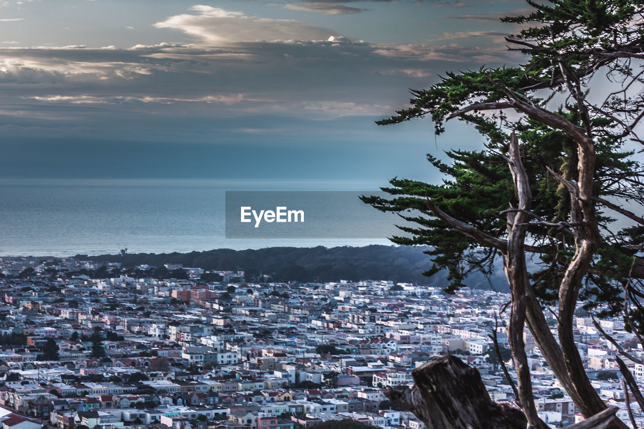 Scenic view of sea and cityscape against sky