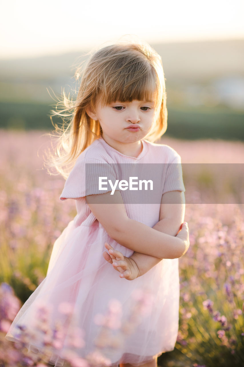 Cute girl standing on flower field