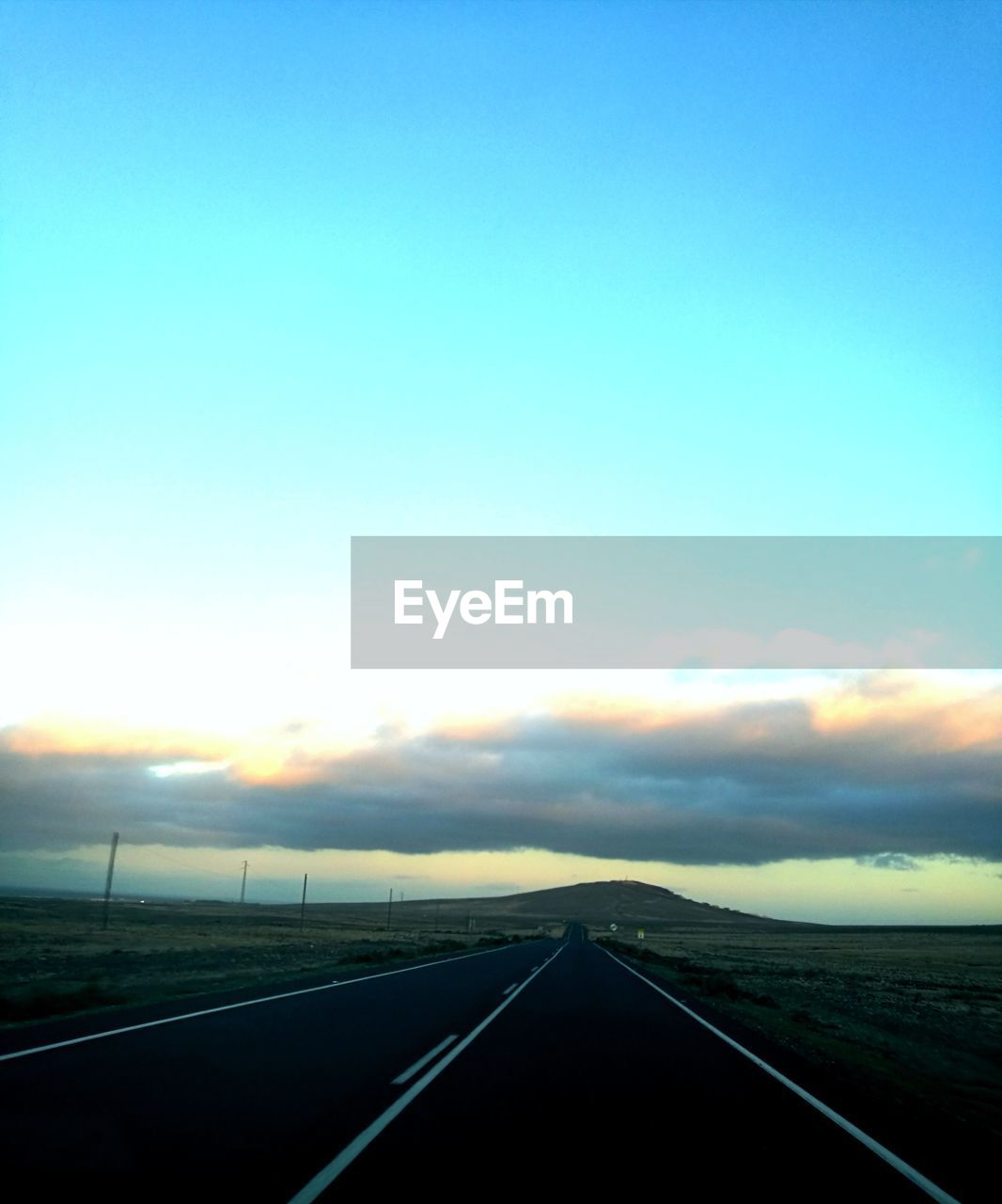 ROAD AMIDST LANDSCAPE AGAINST SKY DURING SUNSET