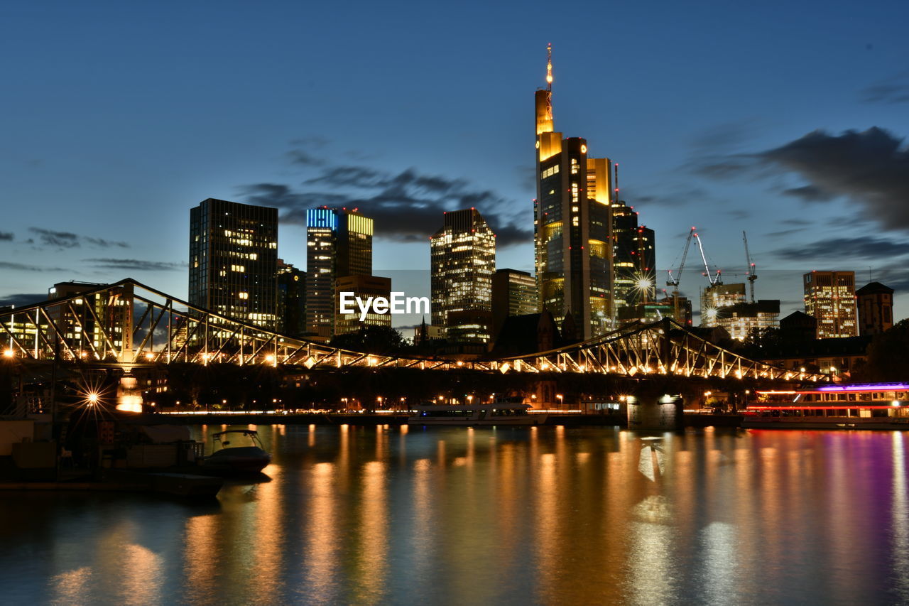 illuminated bridge over river at night