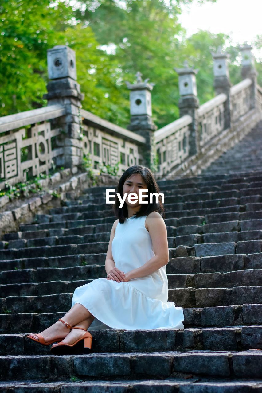 Portrait of woman sitting on staircase