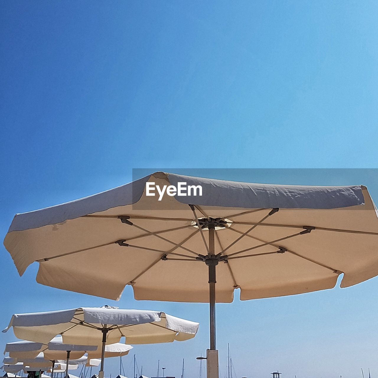 LOW ANGLE VIEW OF AMUSEMENT PARK RIDE AGAINST BLUE SKY