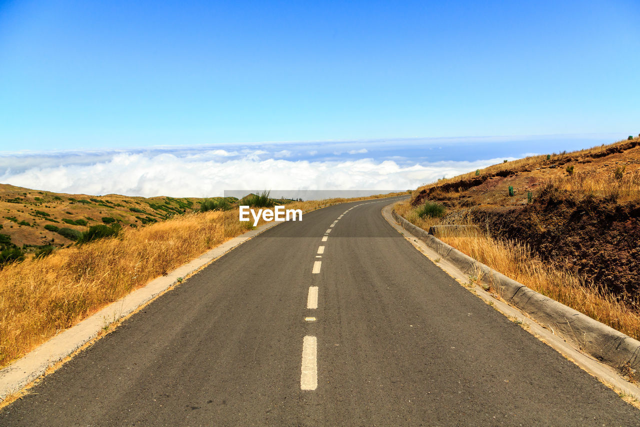 Road amidst landscape against clear blue sky