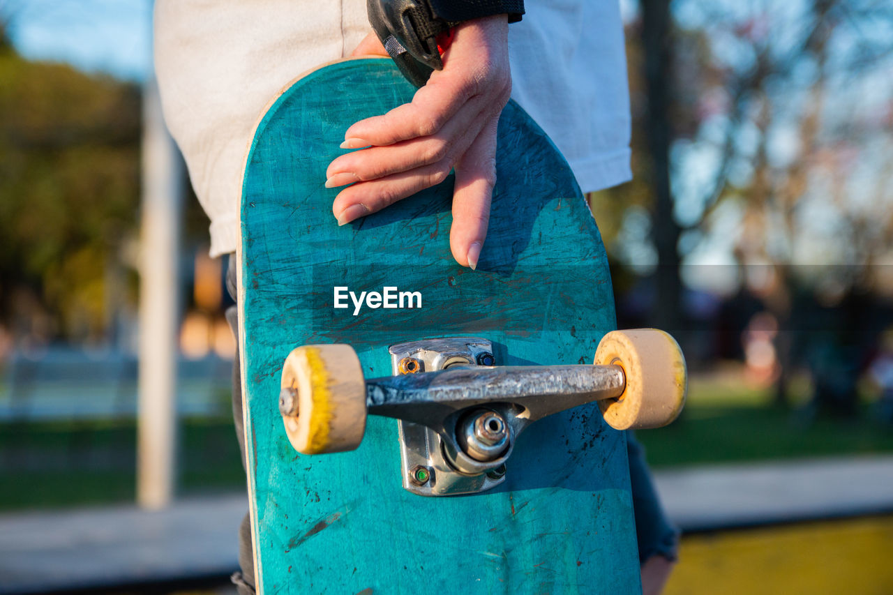 Close-up hand holding skateboard