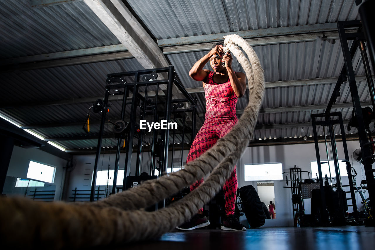 Woman doing training with naval rope. abdominal strengthening and muscular endurance.