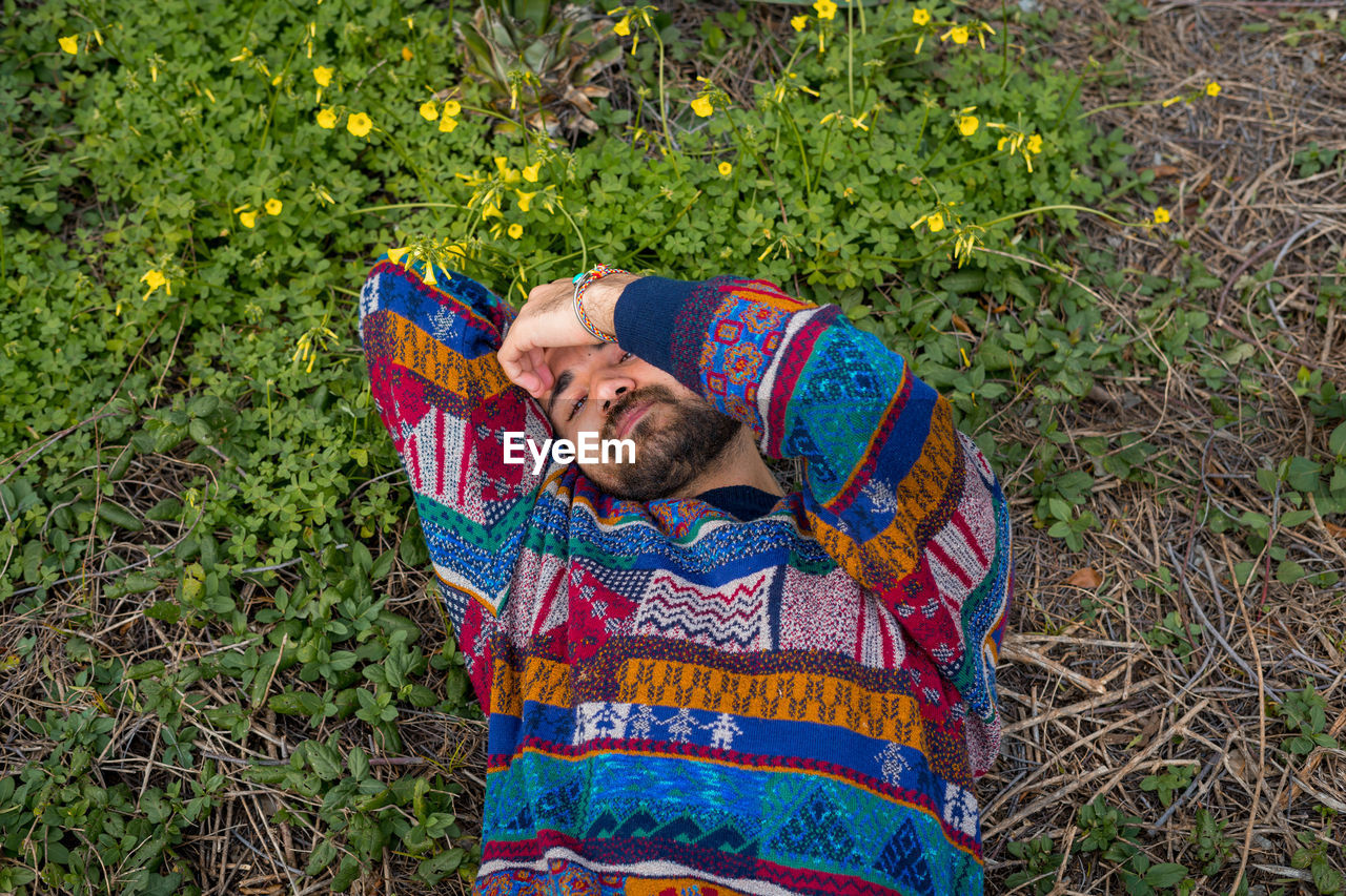 Moroccan man laying on the ground with his hand over his face