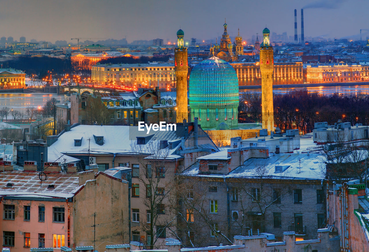 HIGH ANGLE VIEW OF ILLUMINATED BUILDINGS IN CITY