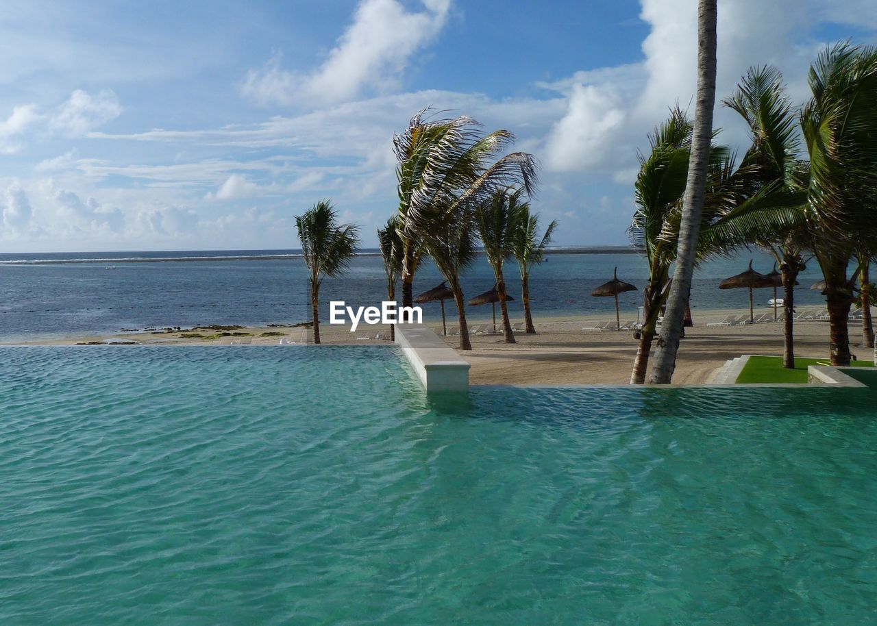 Scenic view of beach against cloudy sky